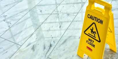 clean floor with a 'caution - wet floor' yellow pop-up sign.
