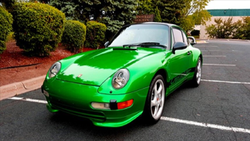 green car parked in a parking lot
