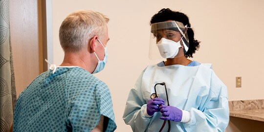 Clinician wearing PPE near patient
