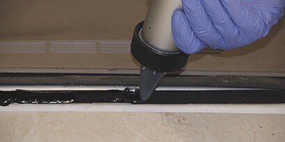 applying window sealer between glass and frame
