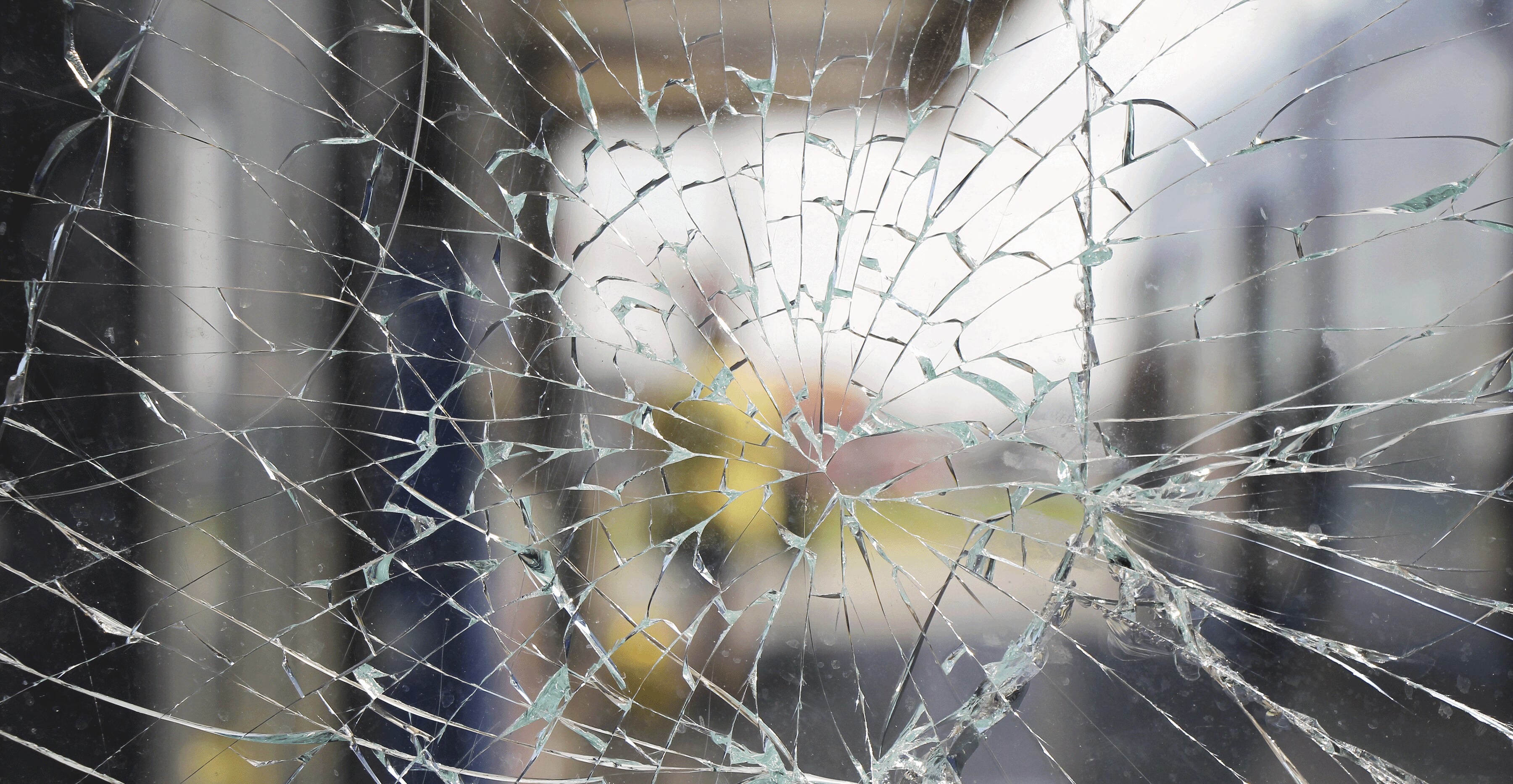 A person dressed in all black tries to look into a home he might want to rob through a window with reflective, security-enhancing window films.
