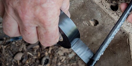 worker wrapping cable with 3M electrical tape
