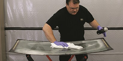 glass technician preparing auto body glass for installation

