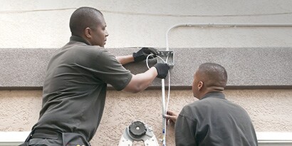 Two electricians working on residential wiring.
