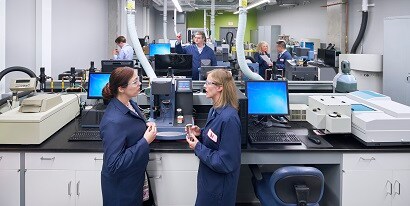 Scientists talking in busy lab

