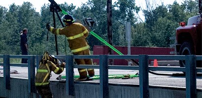 Rescue workers operating vertical confined space davit
