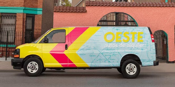 A van wrapped with vibrant yellow, red strips, and blue color, featuring the yellow OSTE wording
