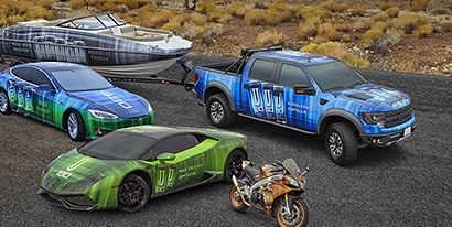 Two cars, with a speedboat wrapped in blue, green, gray and orange 3M Wrap Film Series 2080.
