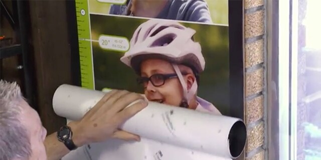 Graphic being placed on a wall of a young boy riding a bike
