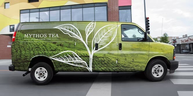 A stationary van wrapped in green sustainable graphic film

