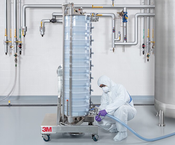  Person in protective clothing working with the next-generation 3M™ Harvest filtration machine
